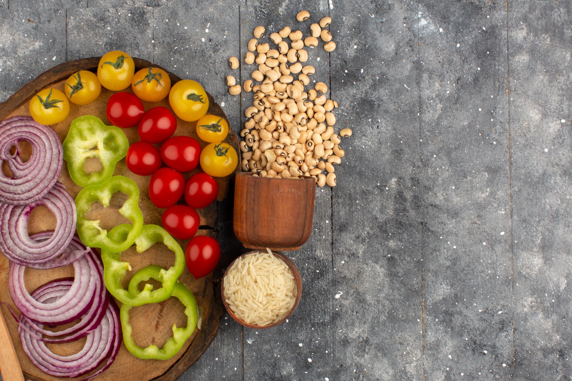 Mesa de madera con verduras frescas y granos integrales dispuestos de forma natural